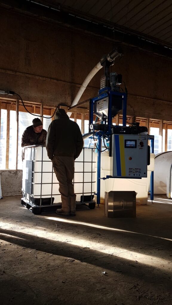 Two men in barn looking at Energrow Pressing System
